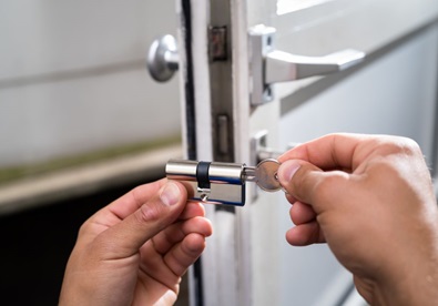 A man replacing a front door lock.
